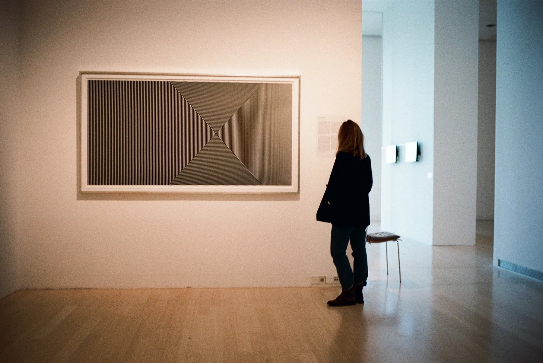 Aux carrés installed in a museum, with a visitor standing before the work